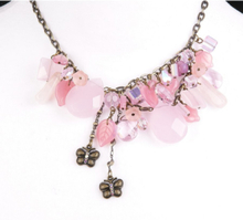 halsketting met roze glaskralen en bronskleurige vlindertjes